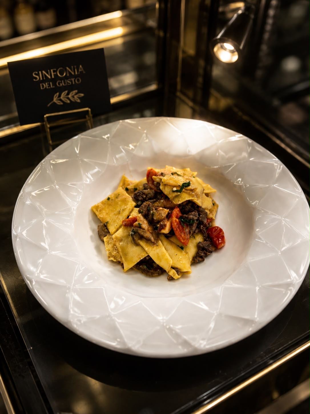 Pappardelle con funghi e pomodorini, piatto servito al tavolo